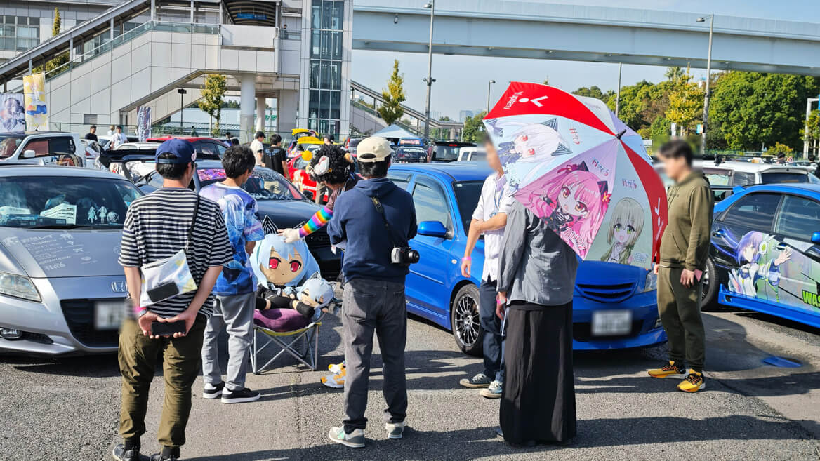 羽衣6の痛車オーナーさん達と談笑するイベントメインMCのジョイまっくすさん